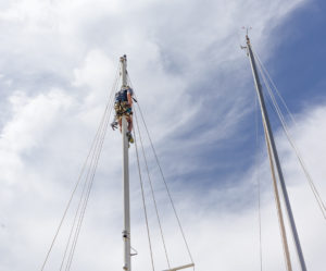 Yacht rigger up a mast fixing yacht rigging