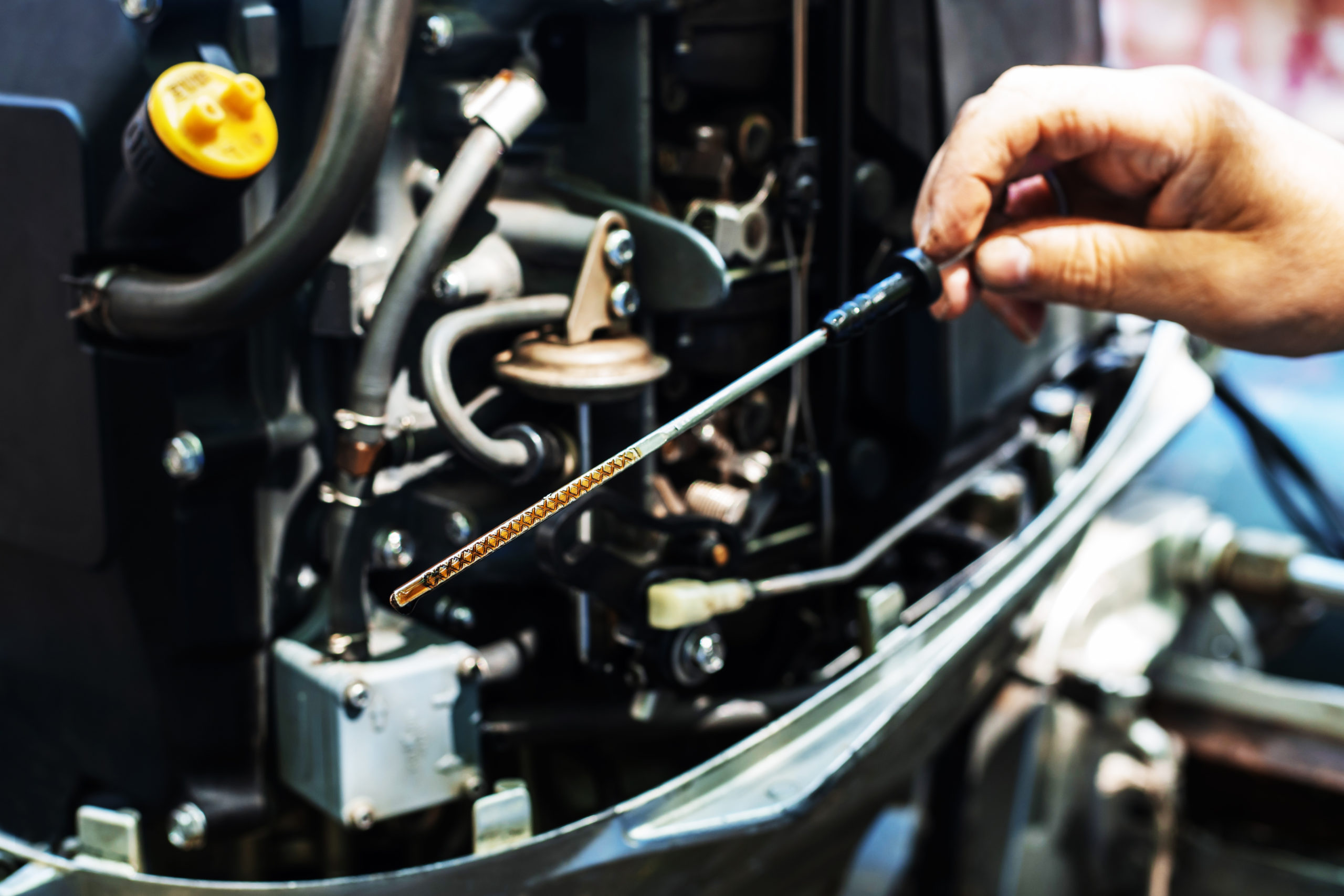 Checking the oil level on a motorboat outboard engine