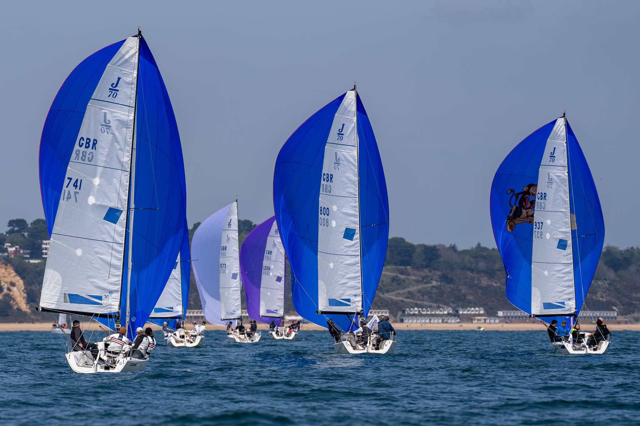 J70 yachts racing at Poole Regatta 2022.  Sandbanks in the background.